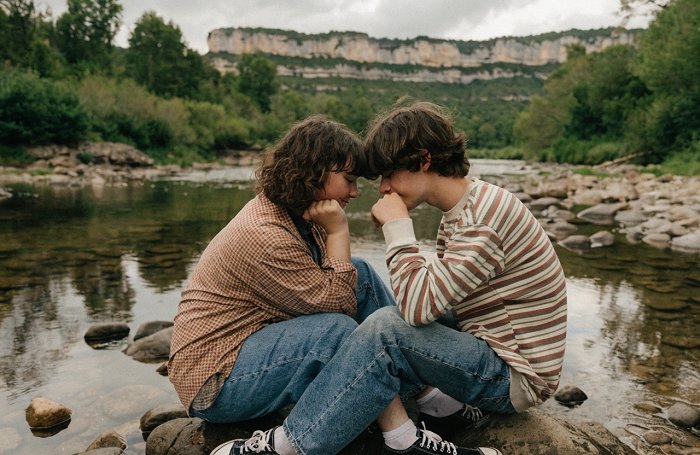 Couple enlacé tendrement au bord de la rivière Ardèche, partageant un moment de douceur et de calme réconfortant